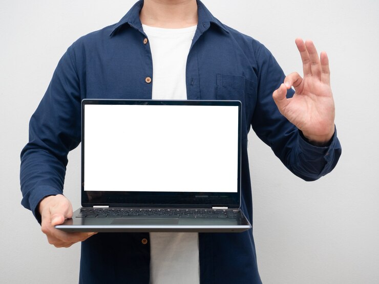 Foto hombre que sostiene la pantalla blanca de la computadora portátil que toma la mano bien recortada