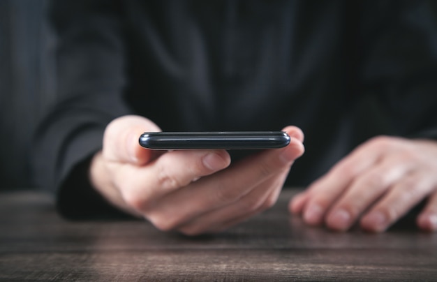 Hombre que sostiene el teléfono inteligente. Concepto de tecnología