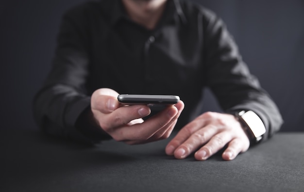 Hombre que sostiene el teléfono inteligente. Concepto de tecnología