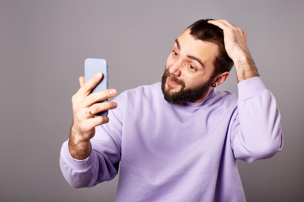 Hombre que sostiene el teléfono inteligente en las manos haciendo videollamadas Comunicación en línea Grabación de video o traducción de la vida