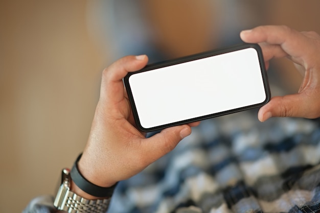 Foto hombre que sostiene el teléfono inteligente móvil de pantalla en blanco