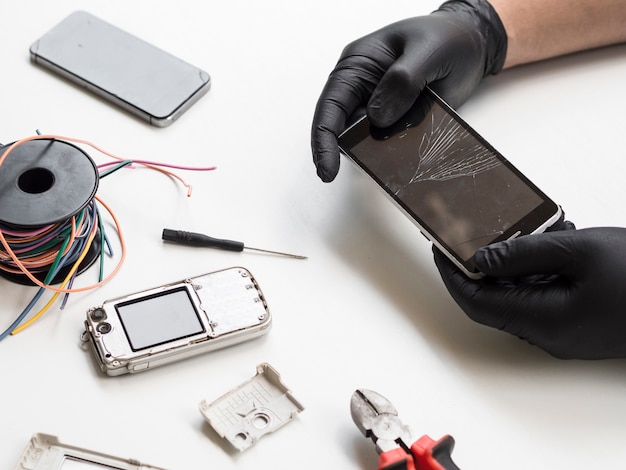 Hombre que sostiene el teléfono con pantalla rota