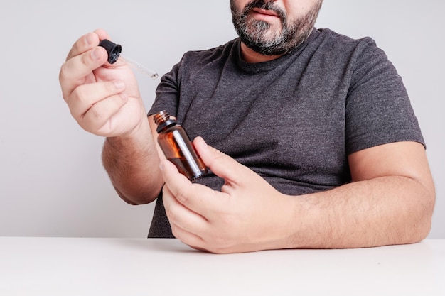 Foto hombre que sostiene el tratamiento facial cosmético fondo blanco