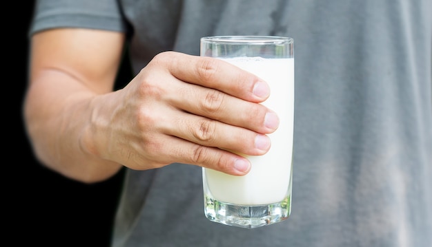 Hombre que sostiene un vaso de leche.