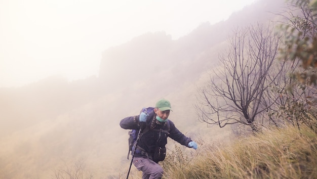 un hombre que sube alegremente una montaña