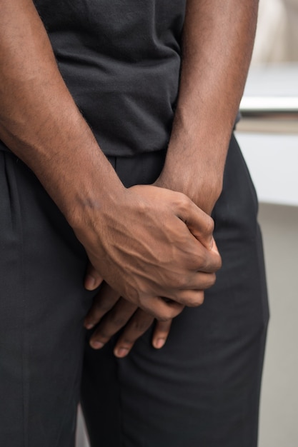 Foto hombre que sufre de cáncer de próstata; hombre africano enfermo con cáncer de próstata, eyaculación precoz, fertilidad, problemas de vejiga; concepto de salud, enfermedad, cáncer; hombre africano adulto, modelo de hombre negro