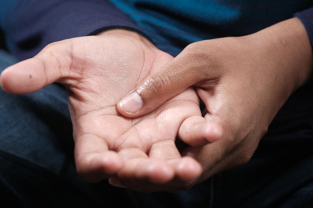 Hombre que sufre dolor en la mano de cerca