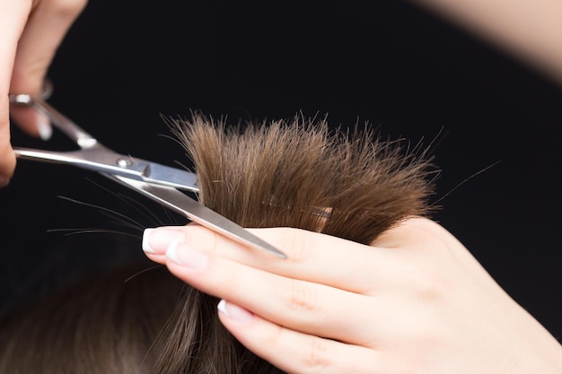 Hombre que tiene un corte de pelo con unas tijeras en el fondo