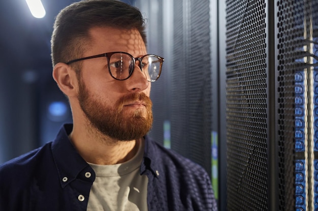 Hombre que trabaja en un centro de datos con gafas