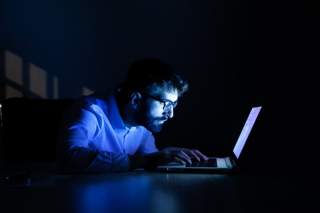 Hombre que trabaja en la computadora por la noche