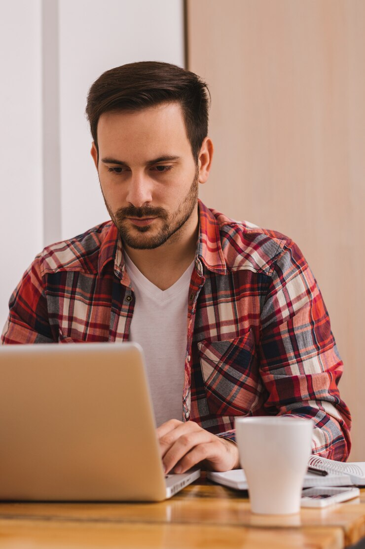 Foto hombre que trabaja en la computadora portátil de casa
