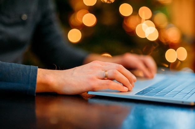 Hombre que trabaja con la computadora portátil en Navidad