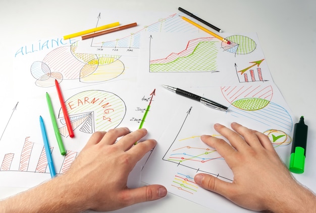 Hombre que trabaja con diagramas de negocios pintados