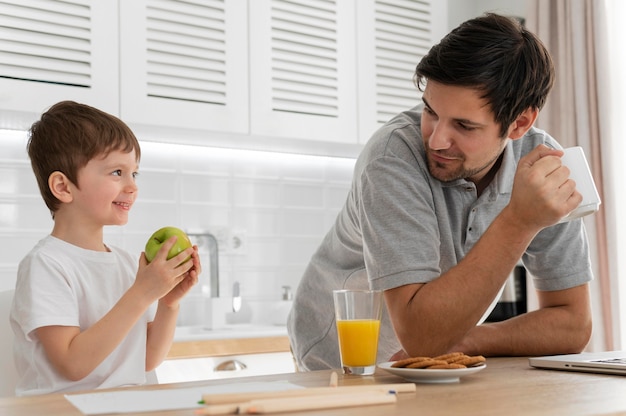 Hombre que trabaja en el escritorio con el hijo