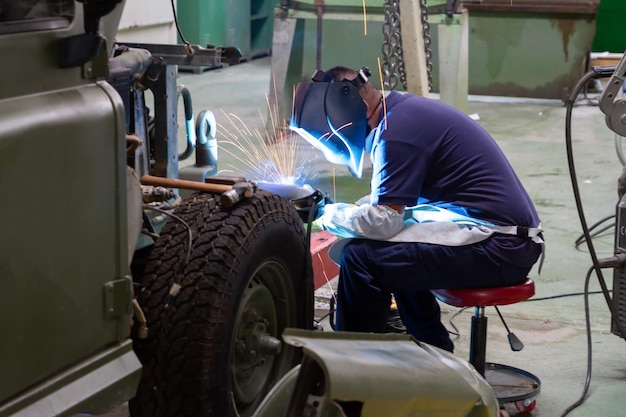 Un hombre que trabaja en un jeep en un taller.