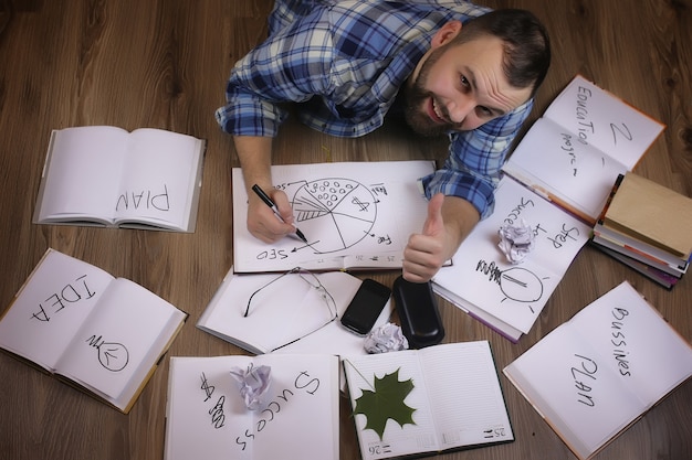 Foto hombre que trabaja con el libro en el concepto de educación y negocios de piso