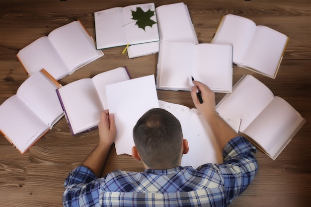 Hombre que trabaja con el libro en el concepto de educación y negocios de piso