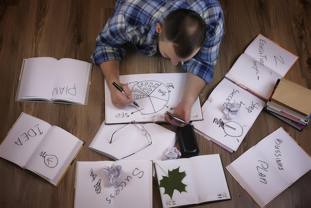 Hombre que trabaja con el libro en el concepto de educación y negocios de piso