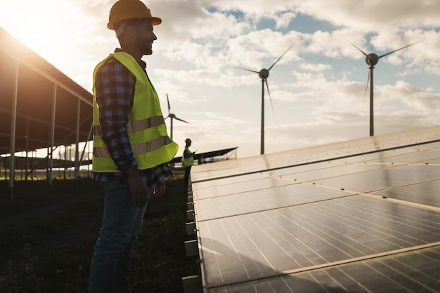 Hombre que trabaja para paneles solares y turbinas eólicas Concepto de energía renovable Centrarse en la cara del trabajador masculino