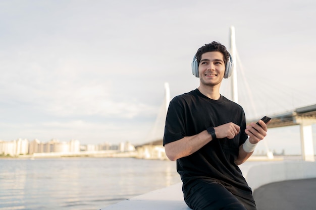 Un hombre que usa una aplicación en su teléfono para escuchar música para entrenar