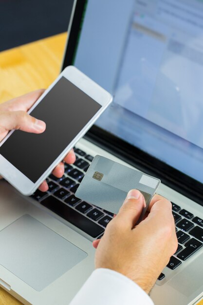 Foto hombre que usa la computadora portátil para ir de compras en línea