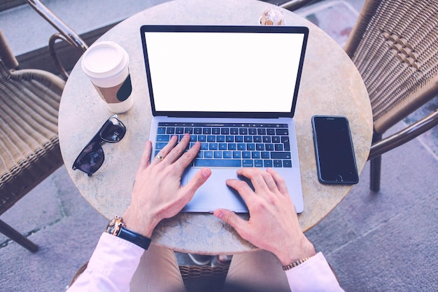 Hombre que usa una computadora portátil con una pantalla de escritorio blanca en blanco