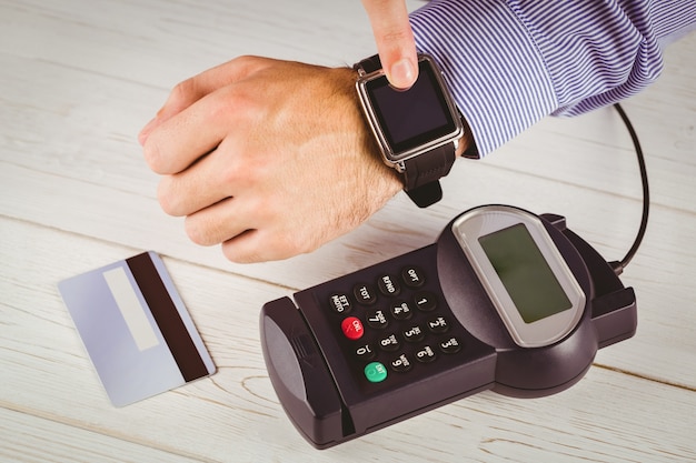 Foto hombre que usa reloj inteligente para expresar pago