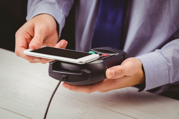 Foto hombre que usa el teléfono inteligente para expresar pago