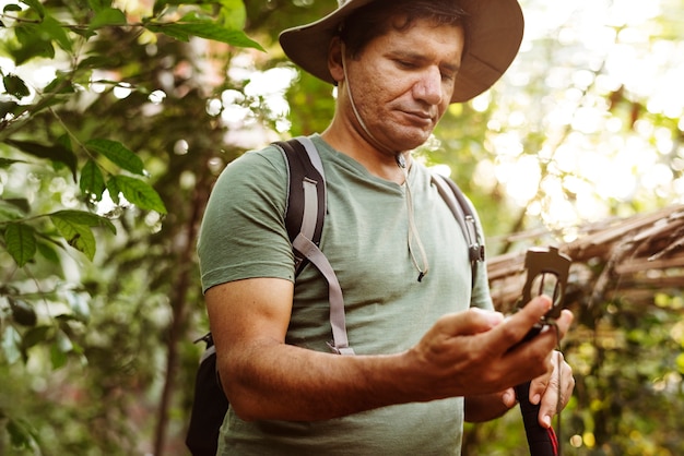 Hombre que usa el teléfono móvil en un bosque