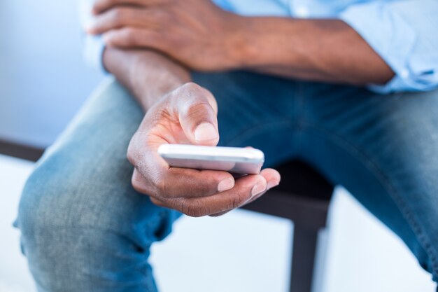 Hombre que usa el teléfono móvil mientras está sentado