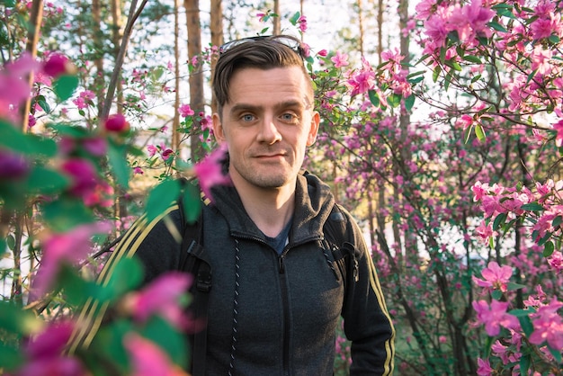 Hombre que viaja en las montañas de altai en primavera hermoso fondo de flores de rododendro rosa en auge