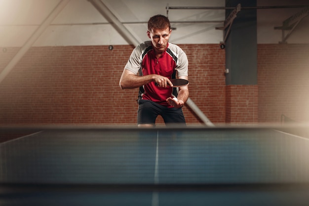 Hombre con raqueta en acción, jugando tenis de mesa