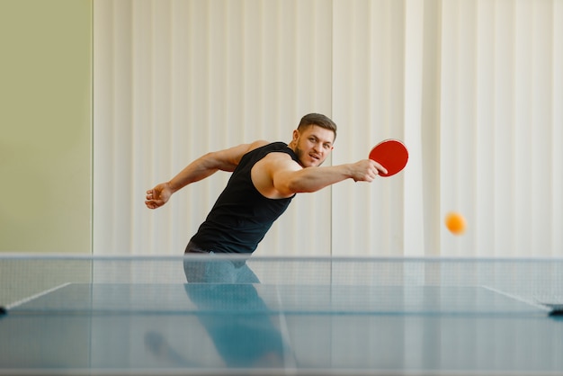 Hombre con raqueta de ping pong juega la pelota