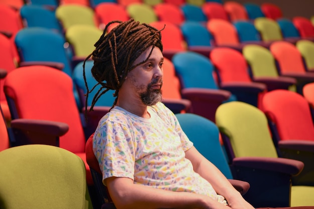 Hombre con rastas sentado solo en un teatro vacío