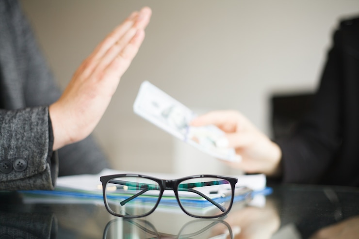 Foto hombre rechazando dinero y vasos sobre la mesa de cristal