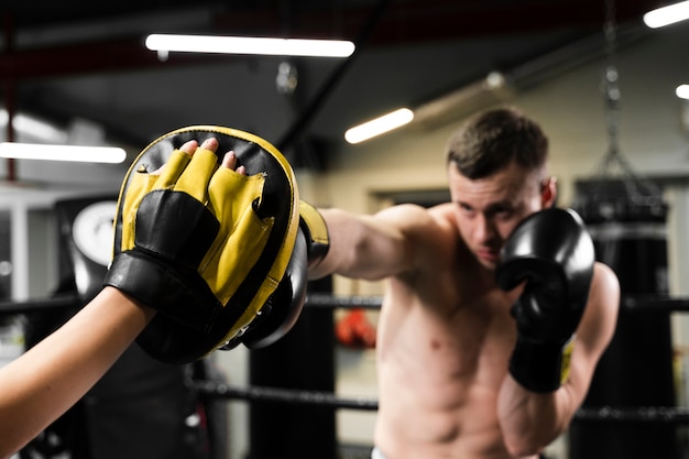 Foto hombre recibiendo ayuda para entrenar duro para una competencia de boxeo