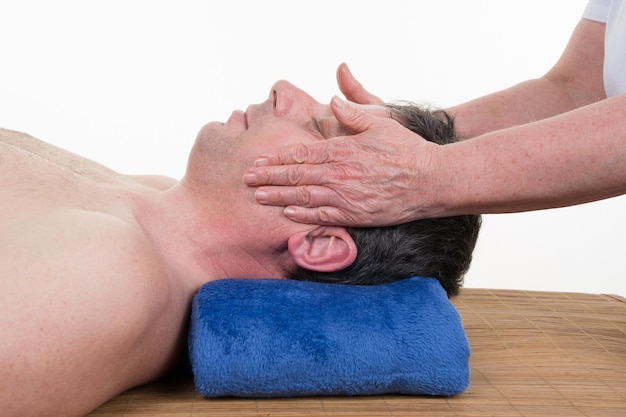 Hombre recibiendo masaje en la cabeza en el centro de belleza