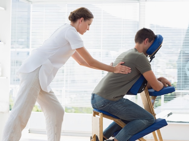 Hombre recibiendo masaje de espalda de fisioterapeuta