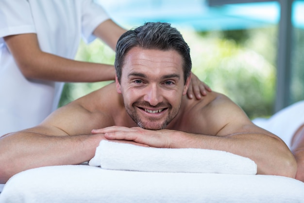 Foto hombre recibiendo masaje de espalda de masajista