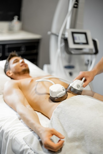 Hombre recibiendo masaje con rodillos de vacío en el centro de belleza