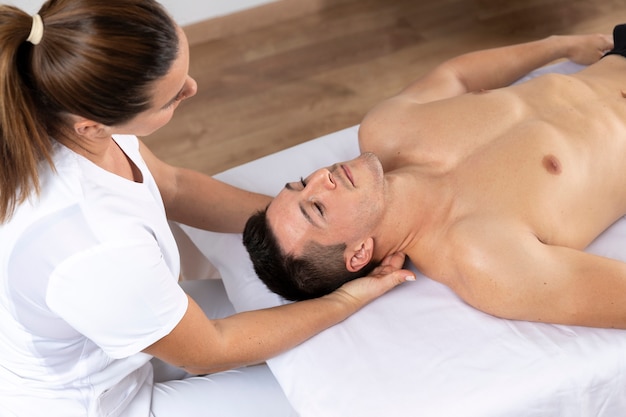 Foto hombre recibiendo masajes durante la sesión de fisioterapia