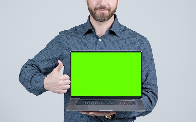 Hombre recortado que muestra la pantalla de la computadora verde para el espacio de copia de presentación de video pulgar hacia arriba