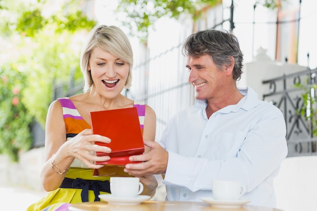 Hombre regalando mujer en café