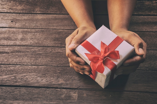 Hombre con regalos de Navidad en un fondo de mesa de madera