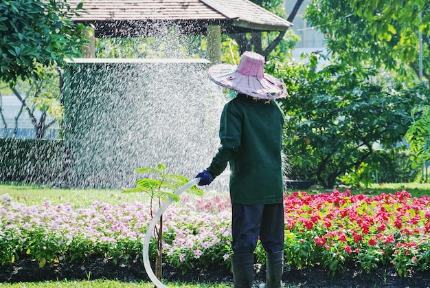 Hombre regando flores en el jardín
