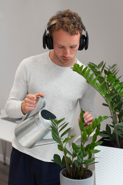 Foto hombre regar las plantas de tiro medio