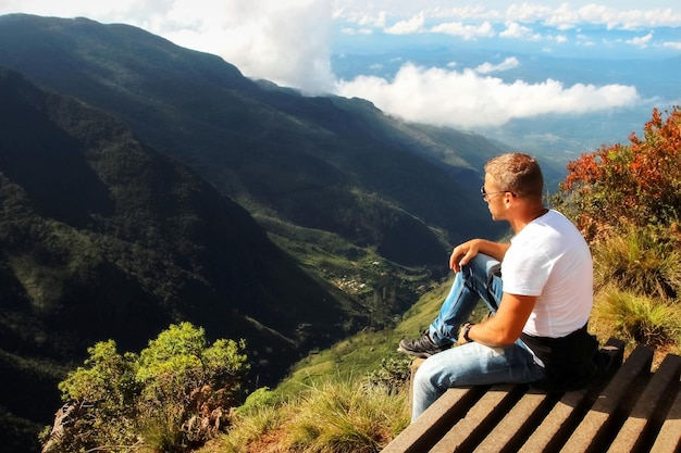 El hombre se relaja en el borde del acantilado Plateau End of the World Sri Lanka