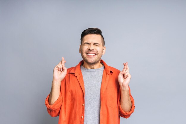 Hombre relajado concentrado con los ojos cerrados relajándose mientras medita tratando de encontrar el equilibrio y la armonía Concepto de yoga y meditación Aislado sobre fondo blanco gris