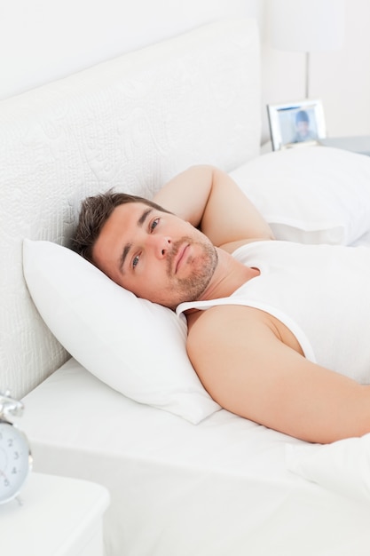 Un hombre relajado en su cama antes de despertarse
