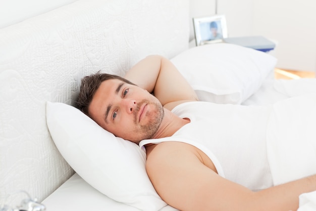 Un hombre relajado en su cama antes de despertarse